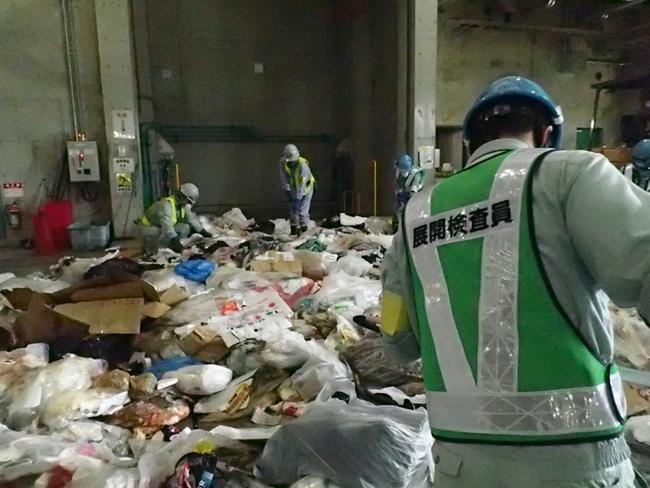 （写真）搬入された事業所のごみを職員が展開検査