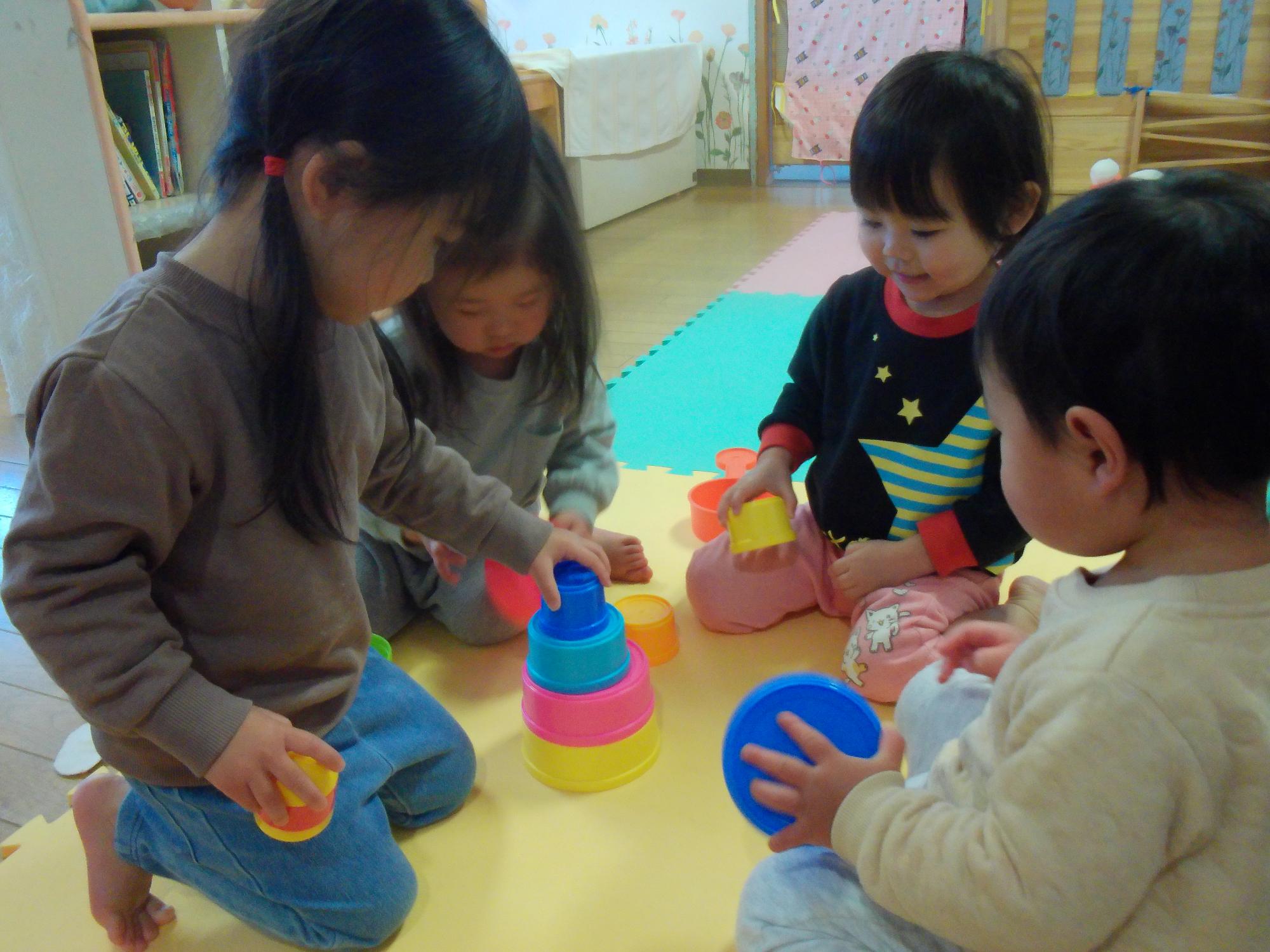 こっぷがさねで遊ぶ子どもたち