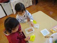 葉っぱに目や口のシールを貼る様子