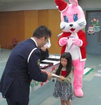 おまわりさんがこどもに修了証書を渡している様子です。
