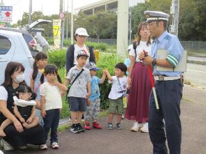 おまわりさんが実地訓練で「安全な信号の渡り方」を教えてくれている様子です。